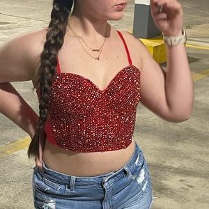 This is a red corset with rhinestones all over it. It was only worn once!